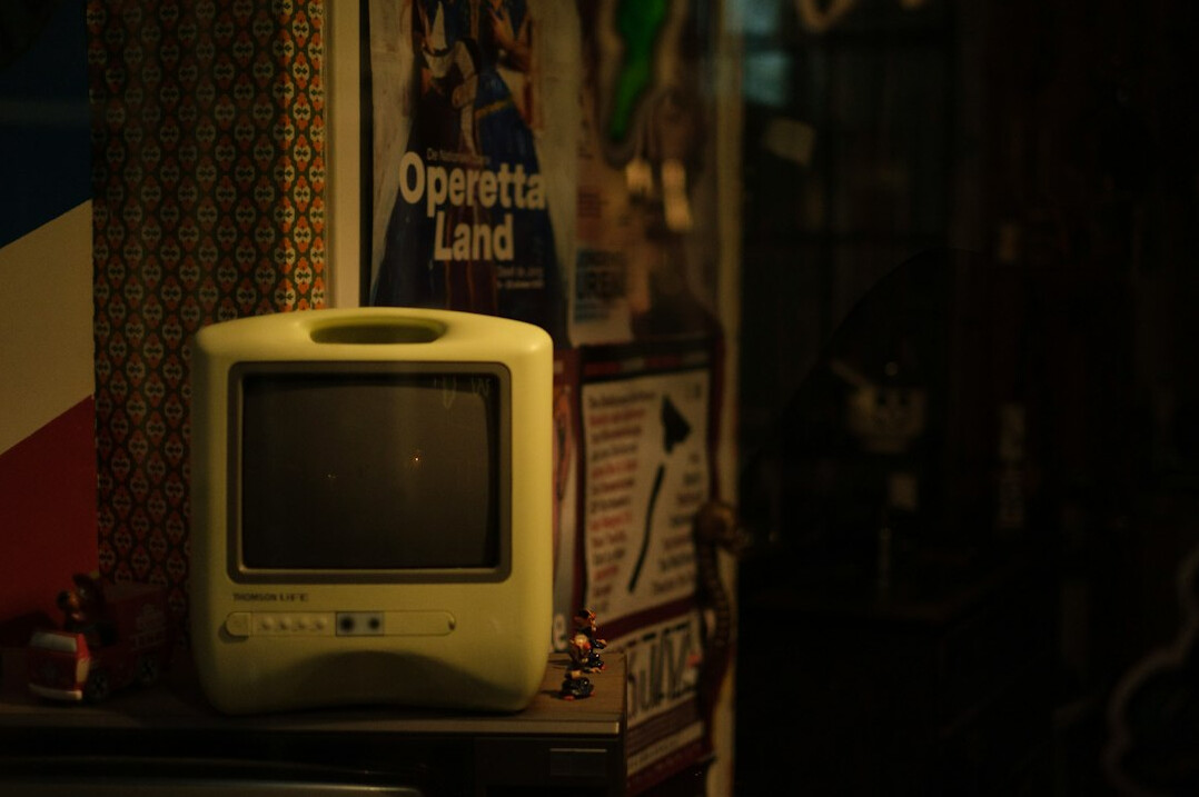 Row of vintage CRT television sets glowing with colourful static